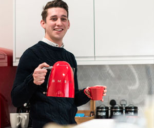 An image of a man using the Kettle in the Small Kitchen
