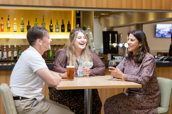 People laughing whilst sat at a bar table